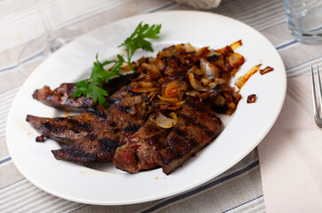 Tasty cooked fried liver pork with fried onion at plate