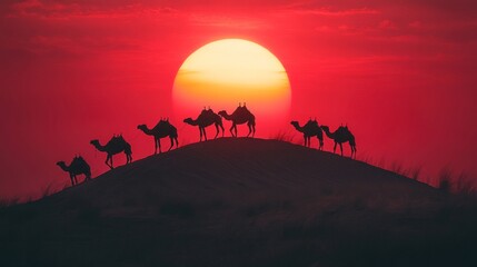 Fototapeta premium Caravan of Camels Silhouetted Against a Red Sunset