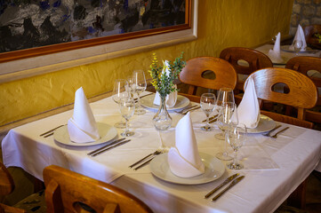 Elegant Table Setting with Fresh Flowers and Napkins in a Cozy Mediterranean Restaurant