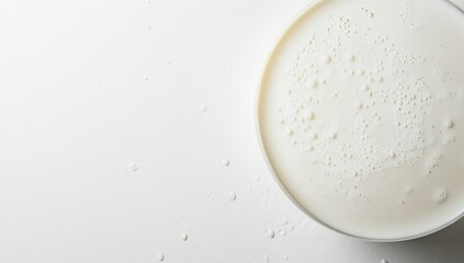 Creamy Milk Texture: Close-Up View of Bubbles and Droplets on a White Surface, Appealing to Senses.