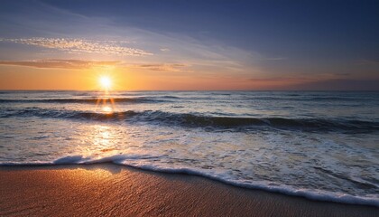 Obraz premium gentle waves kiss the shore as the sun rises casting a serene glow over the horizon
