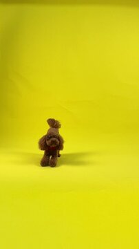 Adorable Cute Brown Dog Figurine Surrounded by a Vibrant and Bright Yellow Background