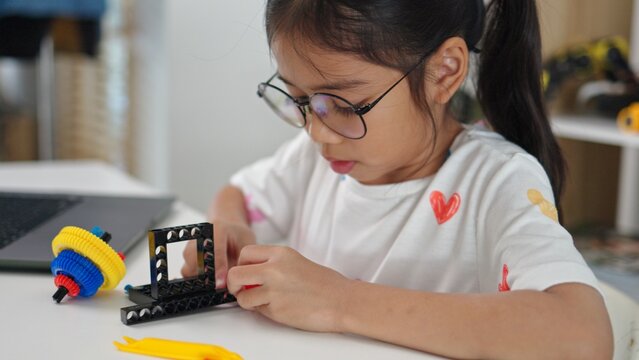 STEM education concept. Asian home school girls self-study online lessons and are excited to make STEM toys. mathematics engineering science technology computer code in robotics for kids' concepts.