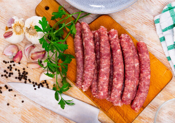 Fresh raw sausage (Longaniza) on kitchen board in restaurant