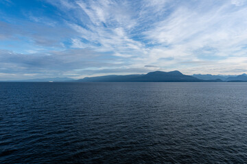 clouds over Strait of Georgia blue sky water landscape mountains on the horizon British Columbia Canada