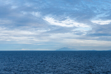 clouds over Strait of Georgia blue sky water landscape mountains on the horizon British Columbia Canada