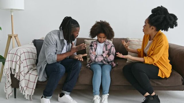 African American parents sort things out with their preschool daughter, yell at her, child resenting parents. Abuse concept, difficulties in the relationship of parents with the child, conflict