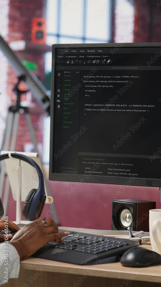 Fototapete Vertical video Developer at computer desk coding while listening music, creating software, implementing algorithms. Remote worker with headphones on at home working with code editor, building