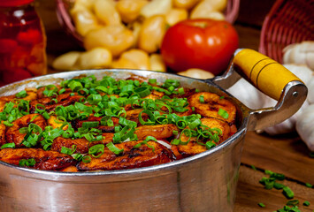 Comida brasileira na panela com arroz, carne, banana frita e temperos