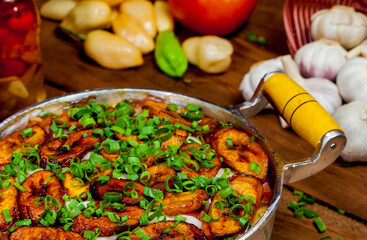 Comida brasileira na panela com arroz, carne, banana frita e temperos
