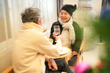 romantic asian senior couple enjoy having meals at night in winter,celebrating christmas and new year's eve at a cozy home together