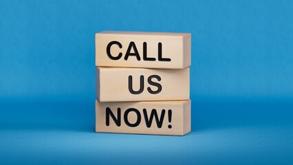 Call us now symbol. Wooden blocks with words Call us now.Business and Call us now concept. Copy space.3D rendering on blue background.