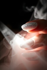 Glittery nails over dry ice smoke.