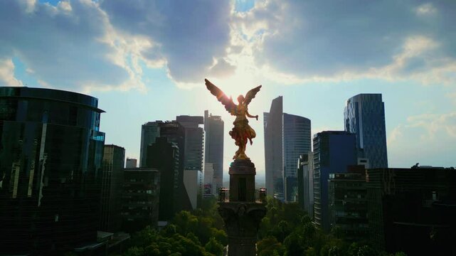 Aerial view from Mexico angel de la independencia monument landmark, cloudy day with sun. Ciudad de M&eacute;xico, monumento angel de la independencia con nubes y sol de fondo, contraluz