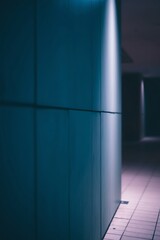 Teal wall and tiled floor in dimly lit corridor.