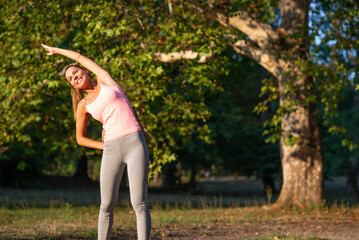 Young woman exercising in the nature in summer