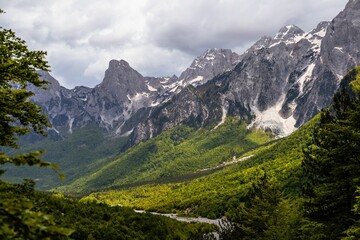 Albanian Alps with lush green valleys and rugged peaks.