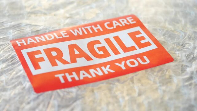 A cardboard box marked with a caution label for fragile goods handling during shipping