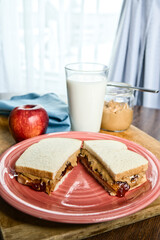 A plate of peanut butter and jelly sandwich and a glass of milk