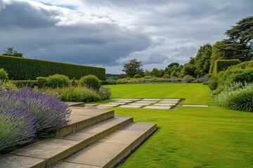 Fototapeta premium The serene landscape of the garden showcases an abundance of lush greenery and blooming lavender, all framed by a soft, cloudy sky, creating a tranquil outdoor escape