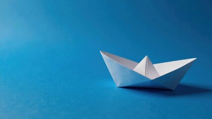 Obraz premium A solitary paper vessel navigates a boundless azure expanse, symbolizing hope, dreams, and the infinite possibilities that lie ahead.
