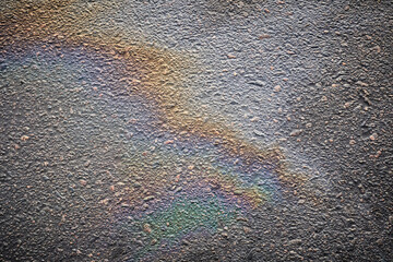 Striking patterns on the road surface from an oil slick highlight the consequences of rain in city...