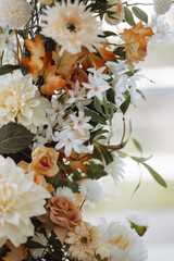 Tall flower arrangement with white and orange flowers. Wedding decorations made of fresh flowers.