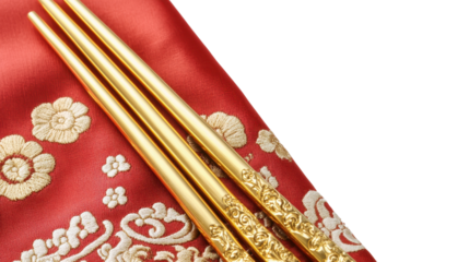 A pair of exquisitely decorated chopsticks rest gracefully on a delicate silk napkin, elevating the dining experience with their refined beauty