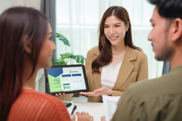 asian financial advisor presenting charts and data on a tablet during couple client meeting.financial planning and decision-making