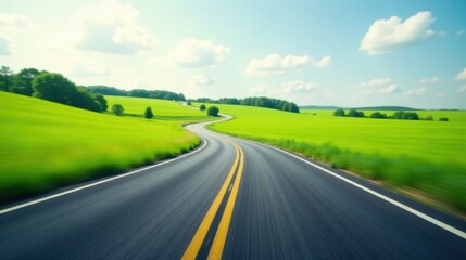Fototapeta premium Asphalt ribbon unwinding through vibrant green fields under a bright summer sky, a journey of open road and endless possibilities.