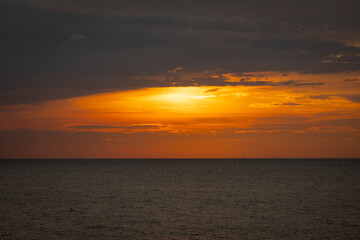 A serene seascape with a distant island silhouetted against the twilight sky