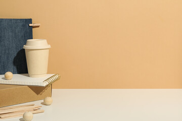 Paper cup, box and notepad on beige background, space for text