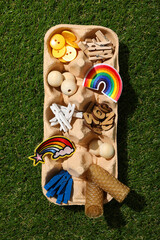 Art supplies in egg tray on green background, top view