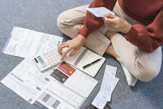 Business financial concept, stressed asian young woman hand checking list with bill for calculate accounting expense credit card payment on due deadline, trying to find money to pay debt on table.