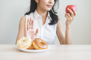 Diet asian young woman hand push out, refuse sugar donut, doughnut and sweet taste on plate and...