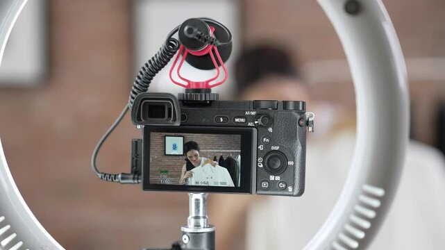 Rear view behide camera screen display woman influencer shoot vlog video review clothes prim social media or blog. Girl with apparel studio lighting for vivancy live streaming marketing recording