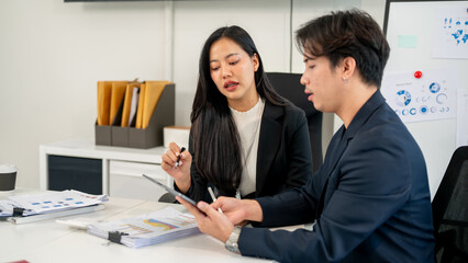 A smart Asian businesswoman shares her ideas with her male colleague during a meeting.