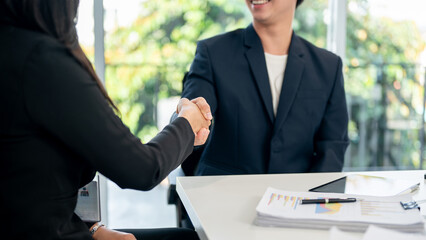 A close-up of a businesswoman shaking hands with a businessman during a meeting. welcome, greeting
