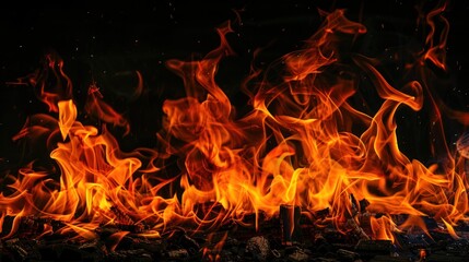 Fiery flames burning brightly against a dark background, ideal for design