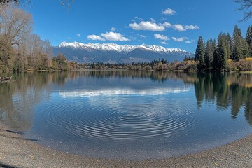 Serene Beach Landscape with Snow-Capped Peaks Reflection in Calm Waters