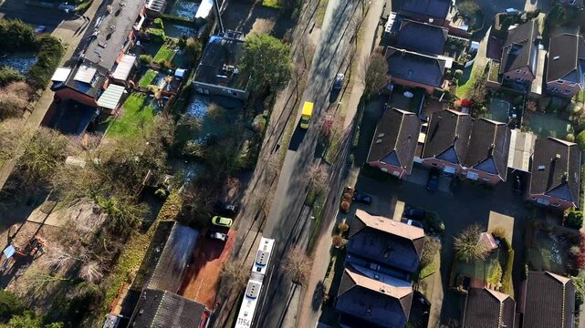 Aerial top down shot of neighborhood with driving bus and DHL Delivery Truck in winter season. Sunny day in german town. Flyover shot.