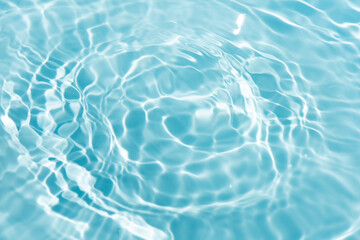 Blue water with ripples on the surface. Defocus blurred transparent blue colored clear calm water surface texture with splashes and bubbles. Water waves with shining pattern texture background.