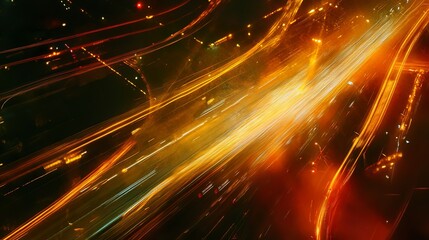 An aerial view captures blurred trails of bright orange and white light winding through a dark landscape, resembling arteries of energy flowing through the night.
