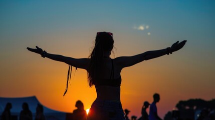 Silhouette of a person with outstretched arms against a vibrant sunset backdrop.