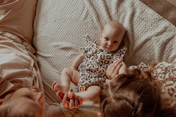 Parents, mom and dad with little baby on bed