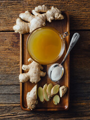 Ginger tea in a glass on wooden background