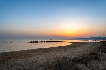 Serene Sandy Beach with a Peaceful Sunset over the Sea