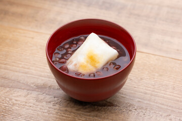 木目のテーブルに香ばしく焼かれたお餅入りのぜんざい