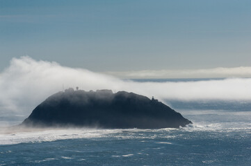 A layer of fog is rolling out over Point Sur, California.