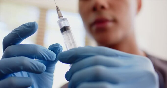Preparing syringe for medical procedure, healthcare worker wearing gloves